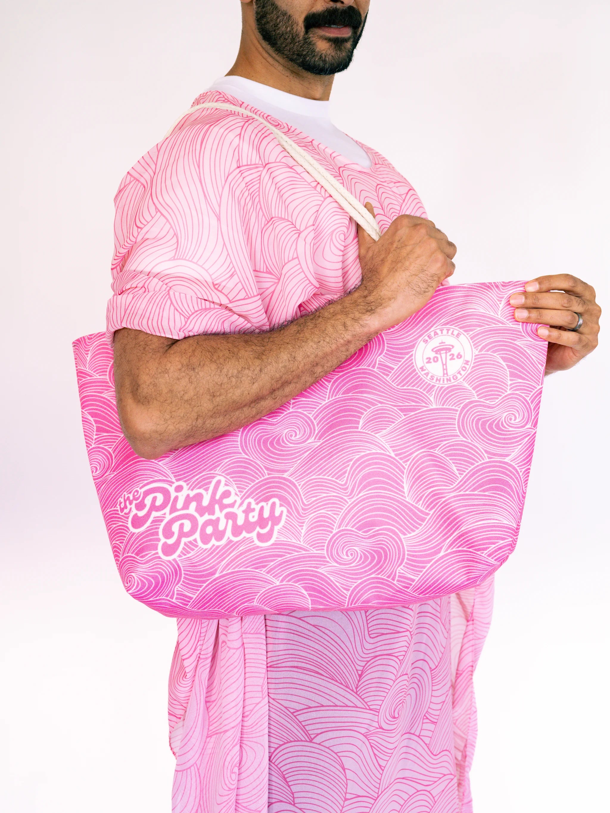Person holding a pink patterned bag with 'Pink Party' text against a white background