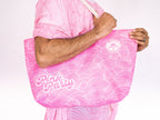Person holding a pink tote bag with 'Pink Party' text on a white background