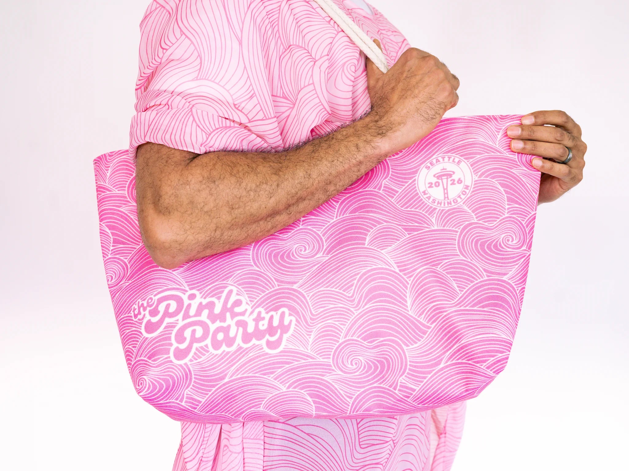 Person holding a pink tote bag with 'Pink Party' text on a white background