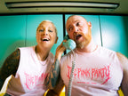 Two people wearing 'The Pink Party' shirts in a room with teal walls.