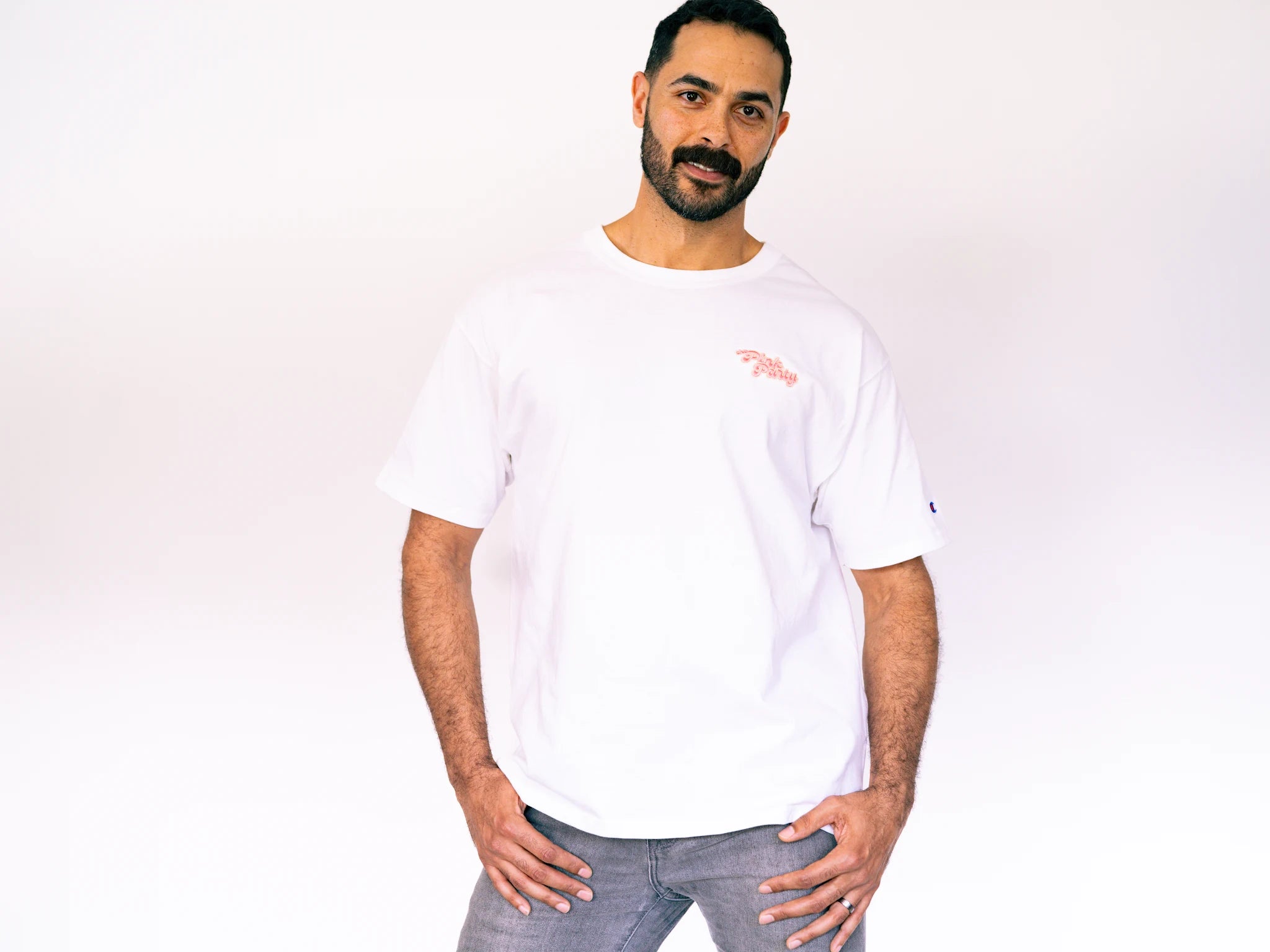 Man wearing a white t-shirt with a logo on a plain background