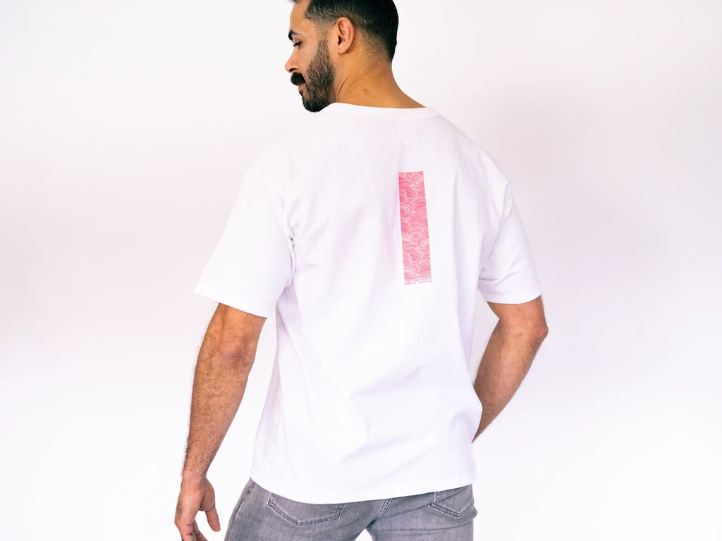 Man wearing a white t-shirt with a red square design on a plain background