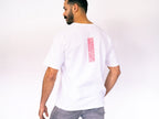 Man wearing a white t-shirt with a red square design on a plain background