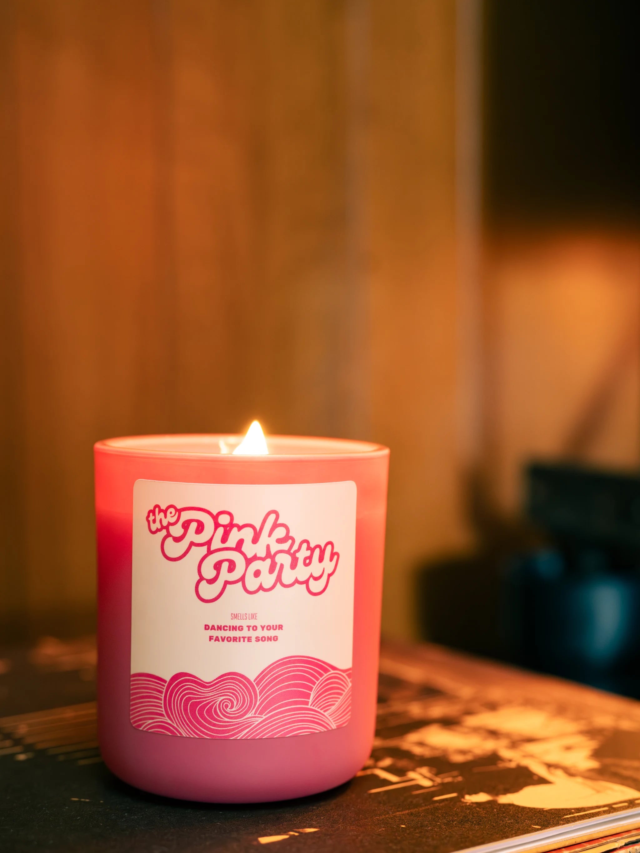 Pink candle with a label on a blurred background