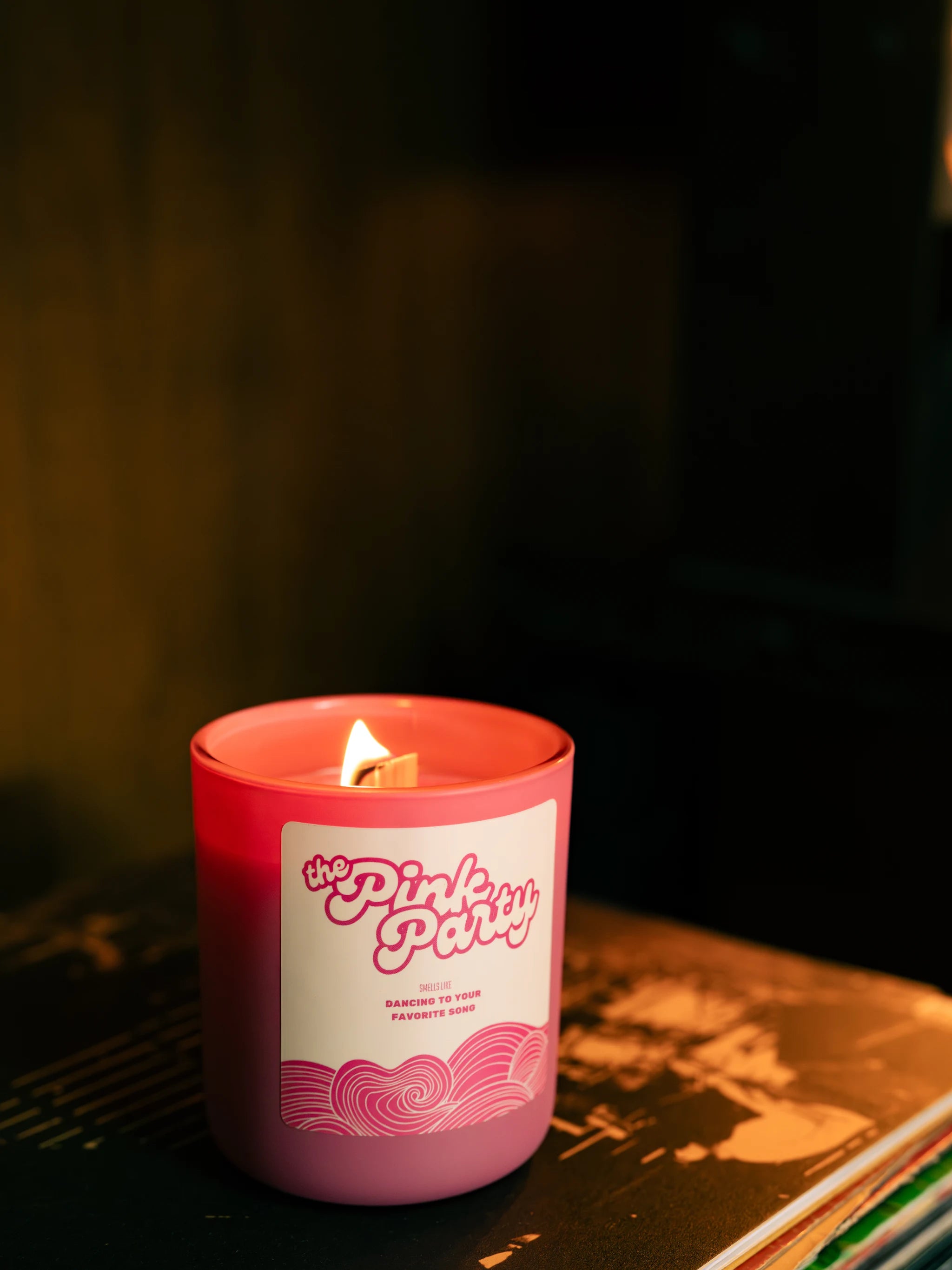 Pink candle with a label in a dark setting