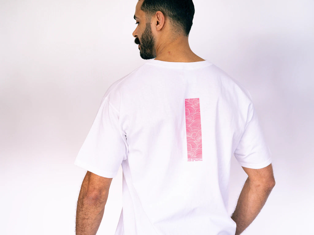 Man wearing a white t-shirt with a pink rectangle on the back against a plain background
