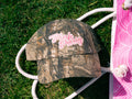 Camouflage-patterned cap with 'Pink Party' text on grass