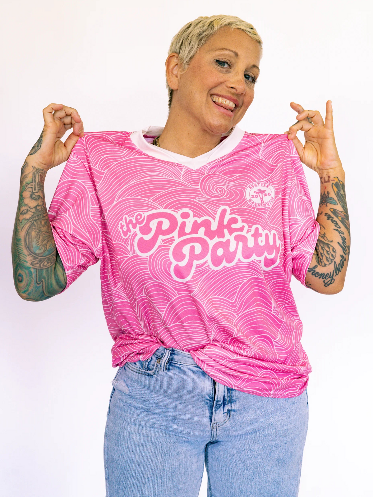 Person wearing a pink 'The Pink Party' shirt with a white background