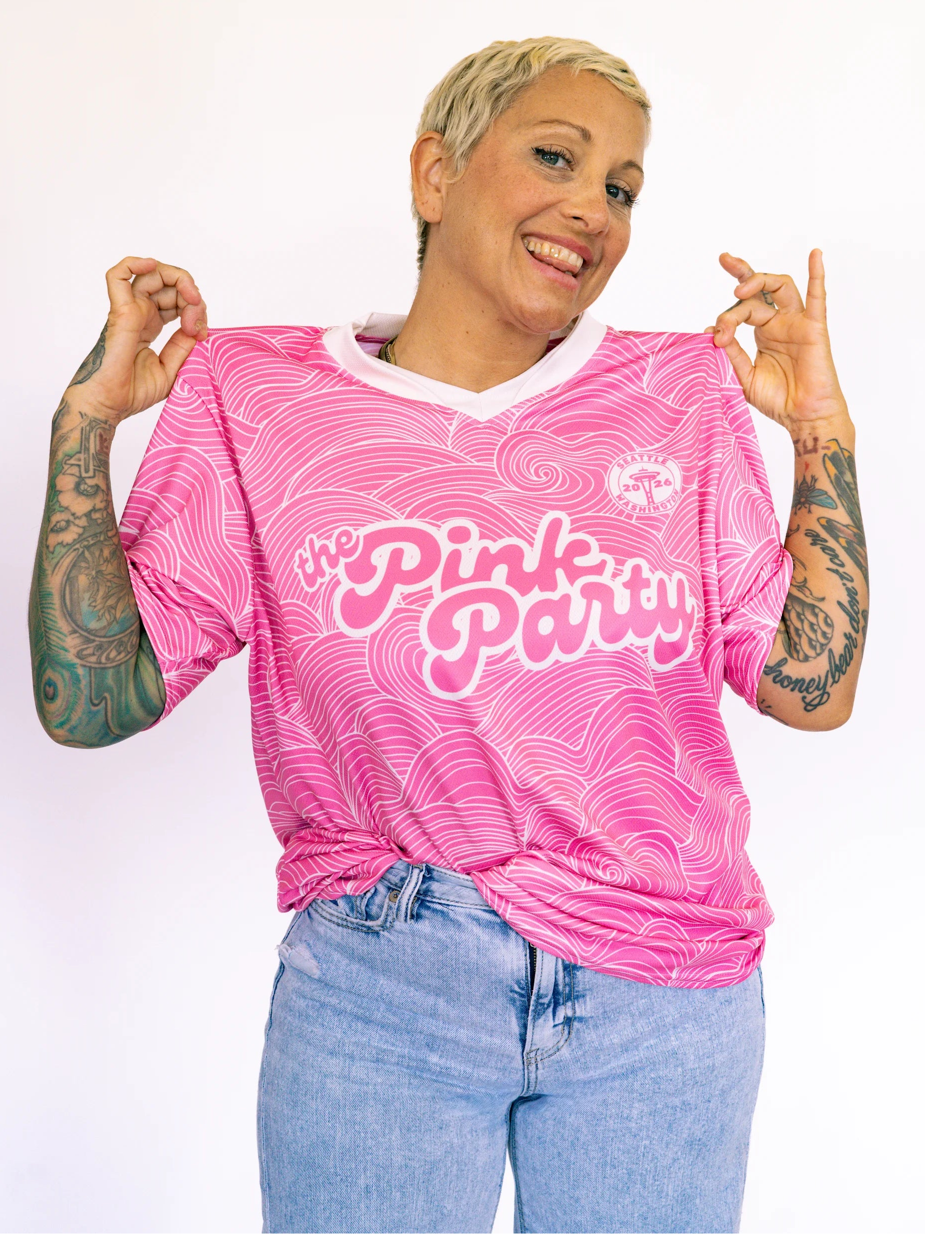 Person wearing a pink 'The Pink Party' shirt with a white background