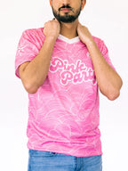 Person wearing a pink t-shirt with white text and patterns on a white background