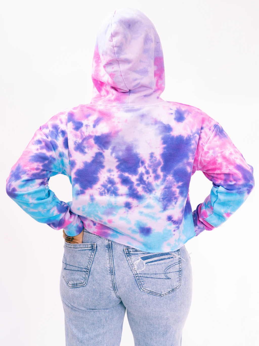 Person wearing a tie-dye hoodie with pink, purple, and blue colors on a white background.