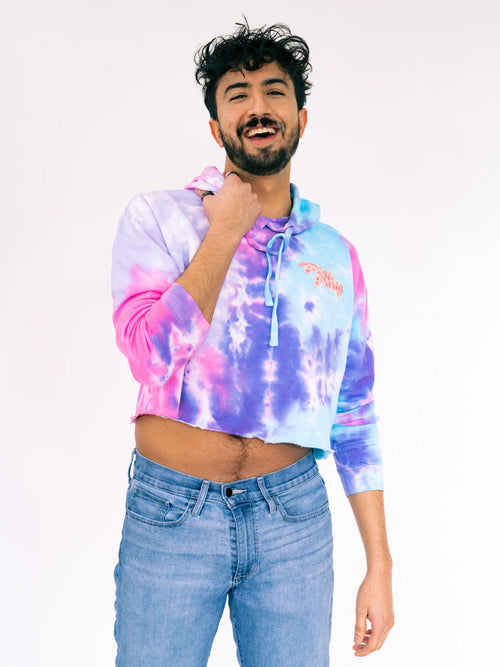 Person wearing a tie-dye hoodie with a plain background