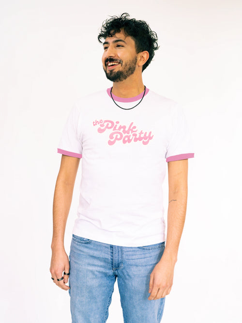 Man wearing a white t-shirt with pink text on a plain background