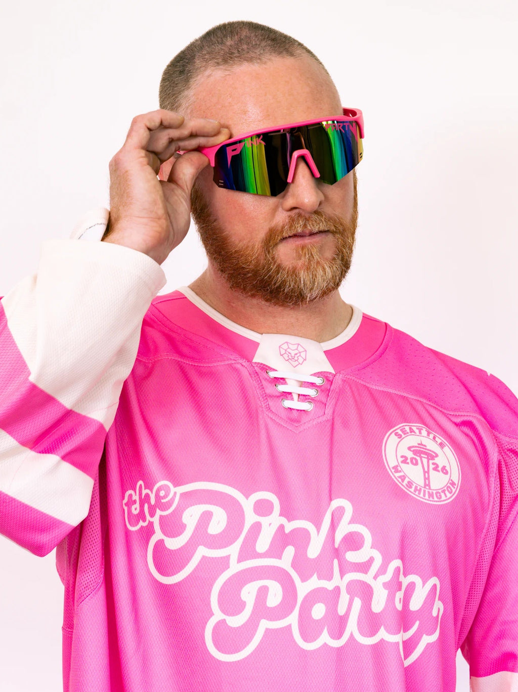 Person wearing a pink hockey jersey with 'the Pink Party' text, holding colorful sunglasses.
