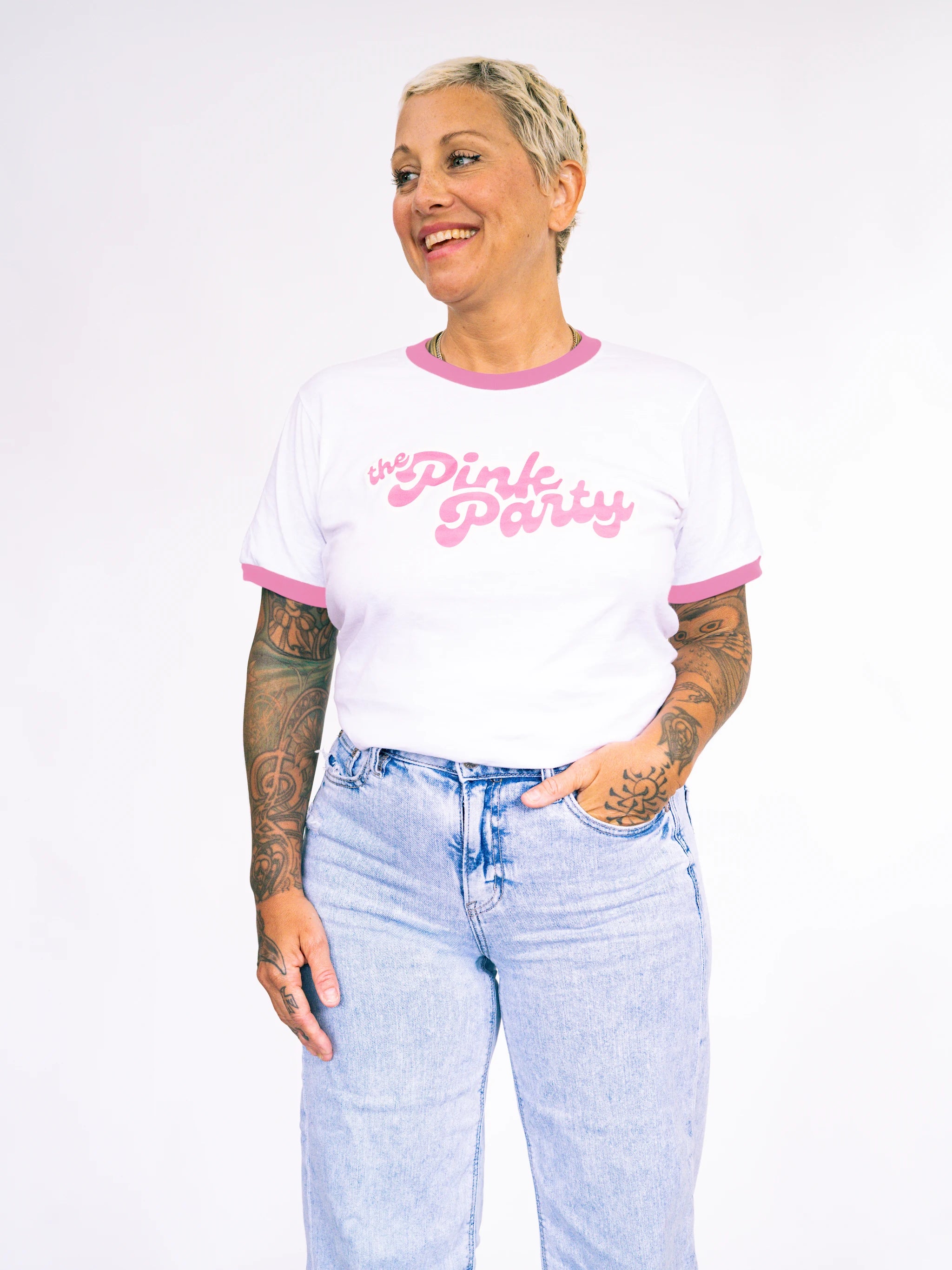 Person wearing a white t-shirt with pink trim and 'Pink Party' text, paired with light blue jeans on a white background.